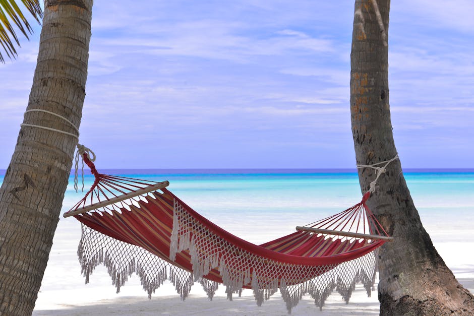 Idyllic beach hammock between coconut trees with azure blue waters